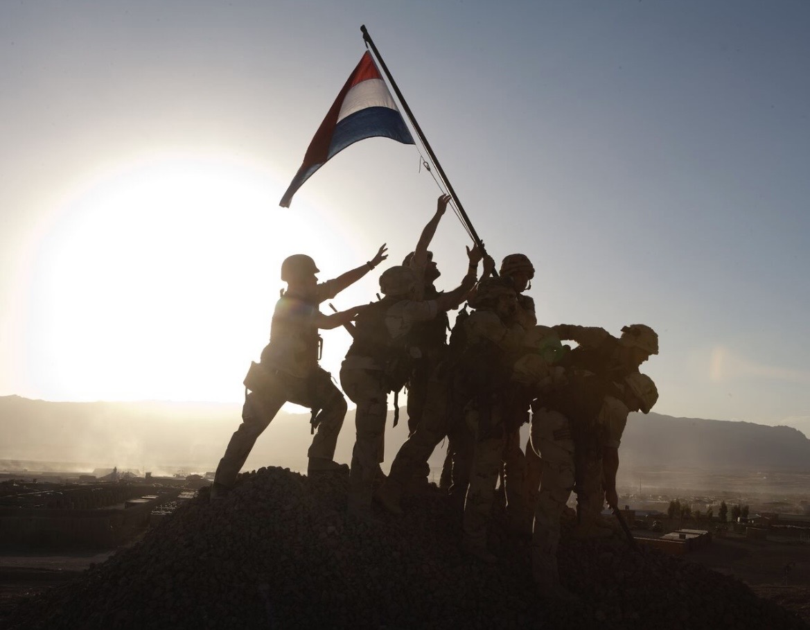 Nederlandse soldaten zetten de Nederlandse vlag op.